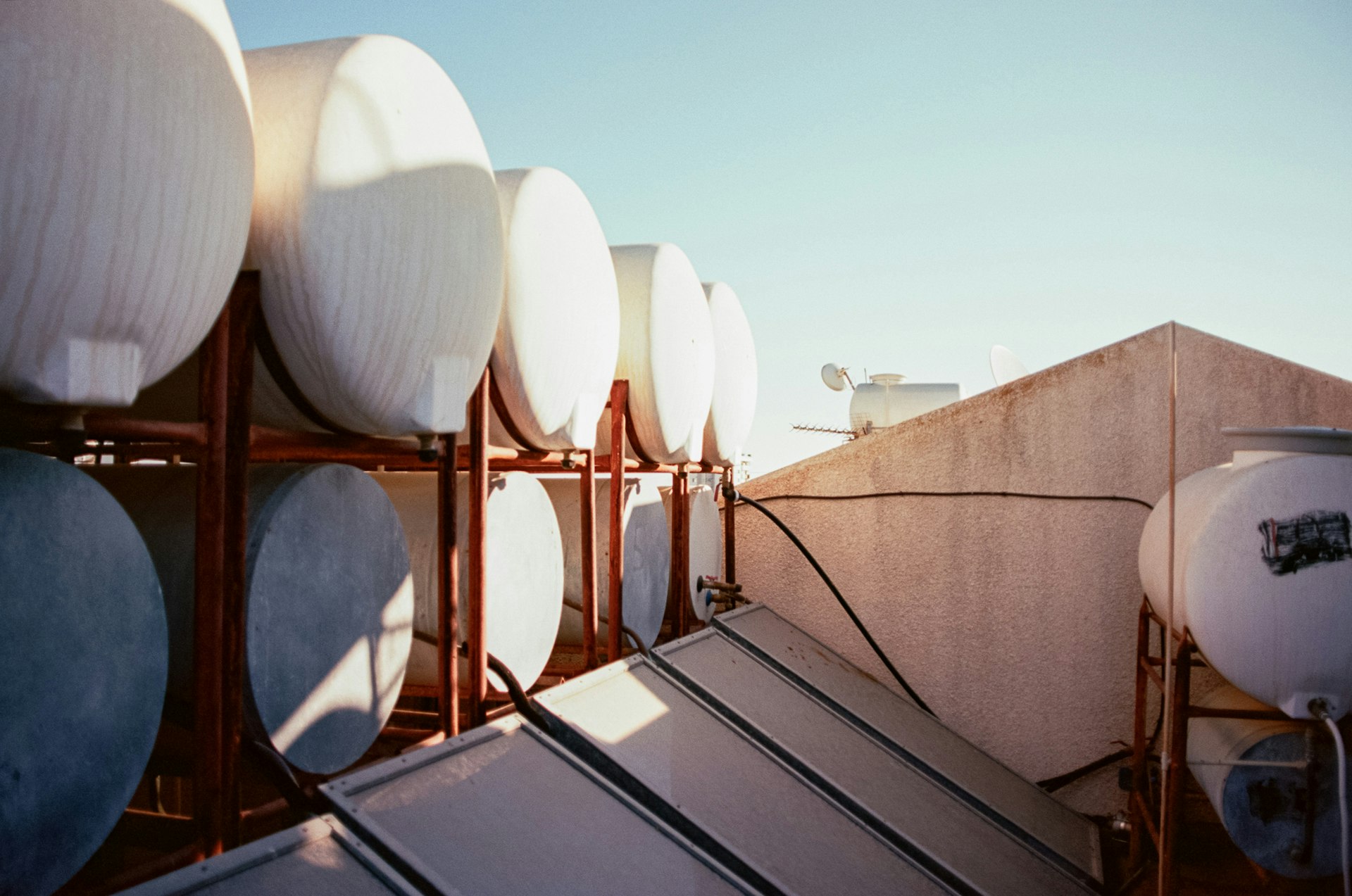 Rooftop solar water heating installation with collector panels and hot water storage tanks